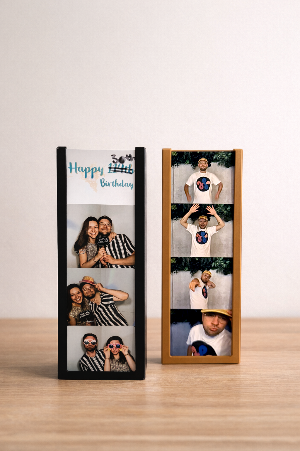 twee stuks WisselFrames Fotobooth op een houten blad met daarin een stapel foto's